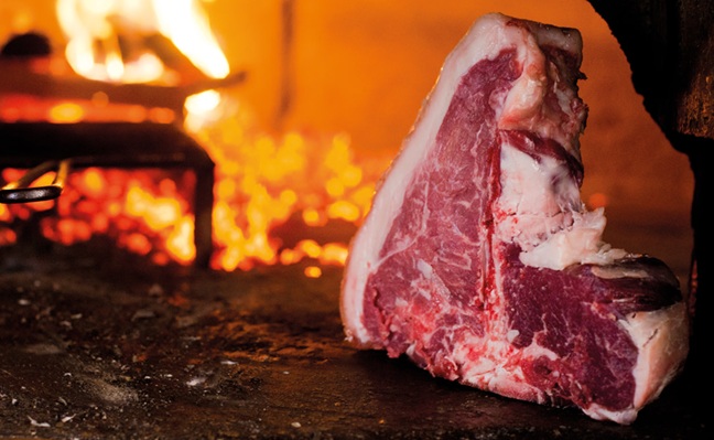 Bistecca alla fiorentina servita su tagliere di legno